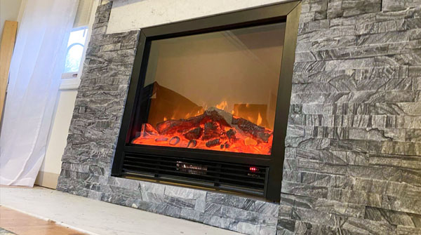 an indoor fireplace with a stone wall